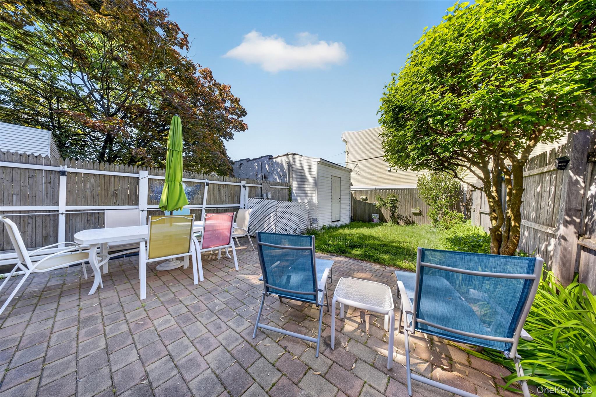 88-42 87th Street Queens, NY 11421 - Photo 27 of 33 a view of a chairs and table in the back yard of the house