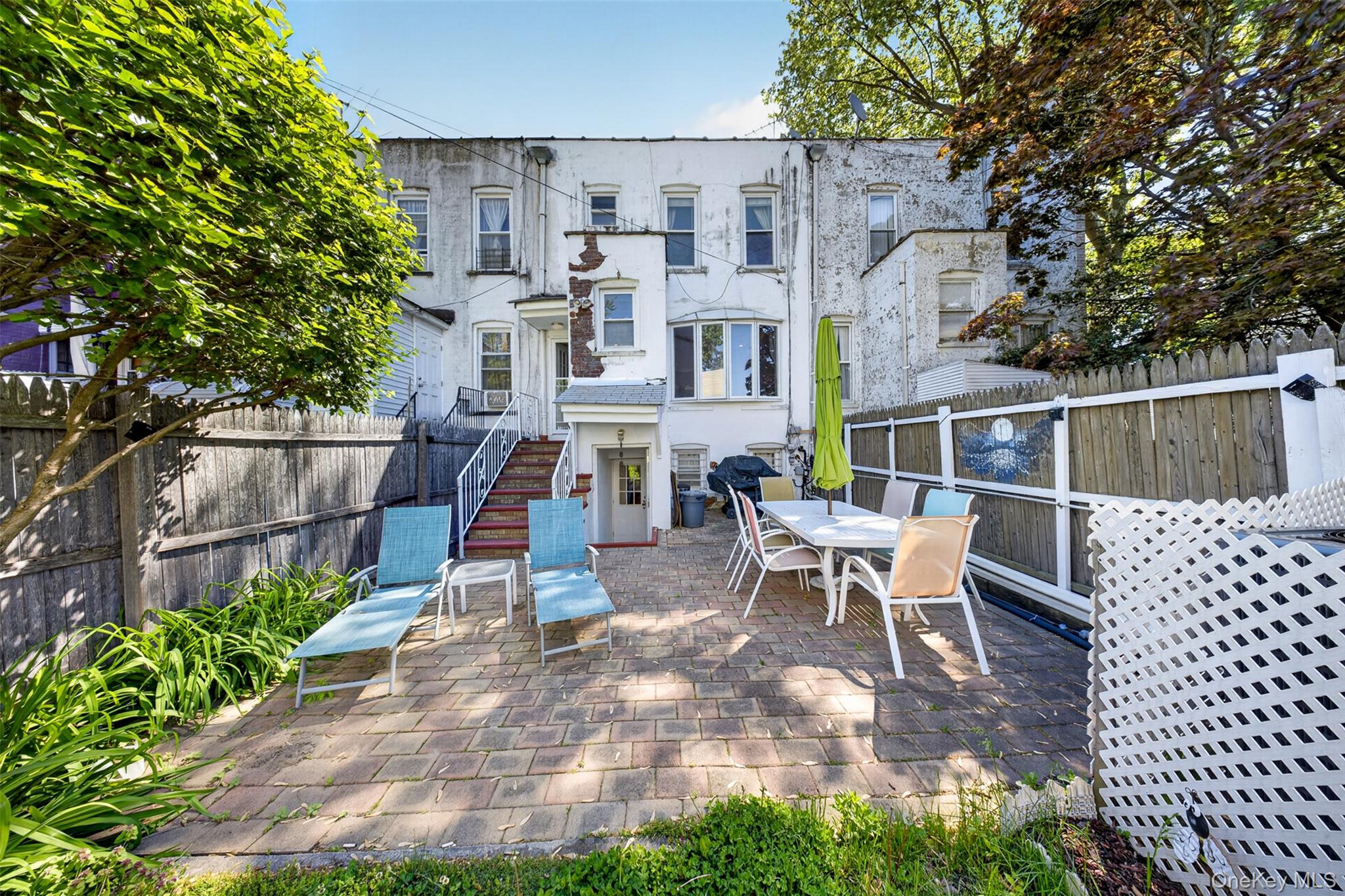 88-42 87th Street Queens, NY 11421 - Photo 28 of 33 a view of a patio with table and chairs with wooden fence and plants