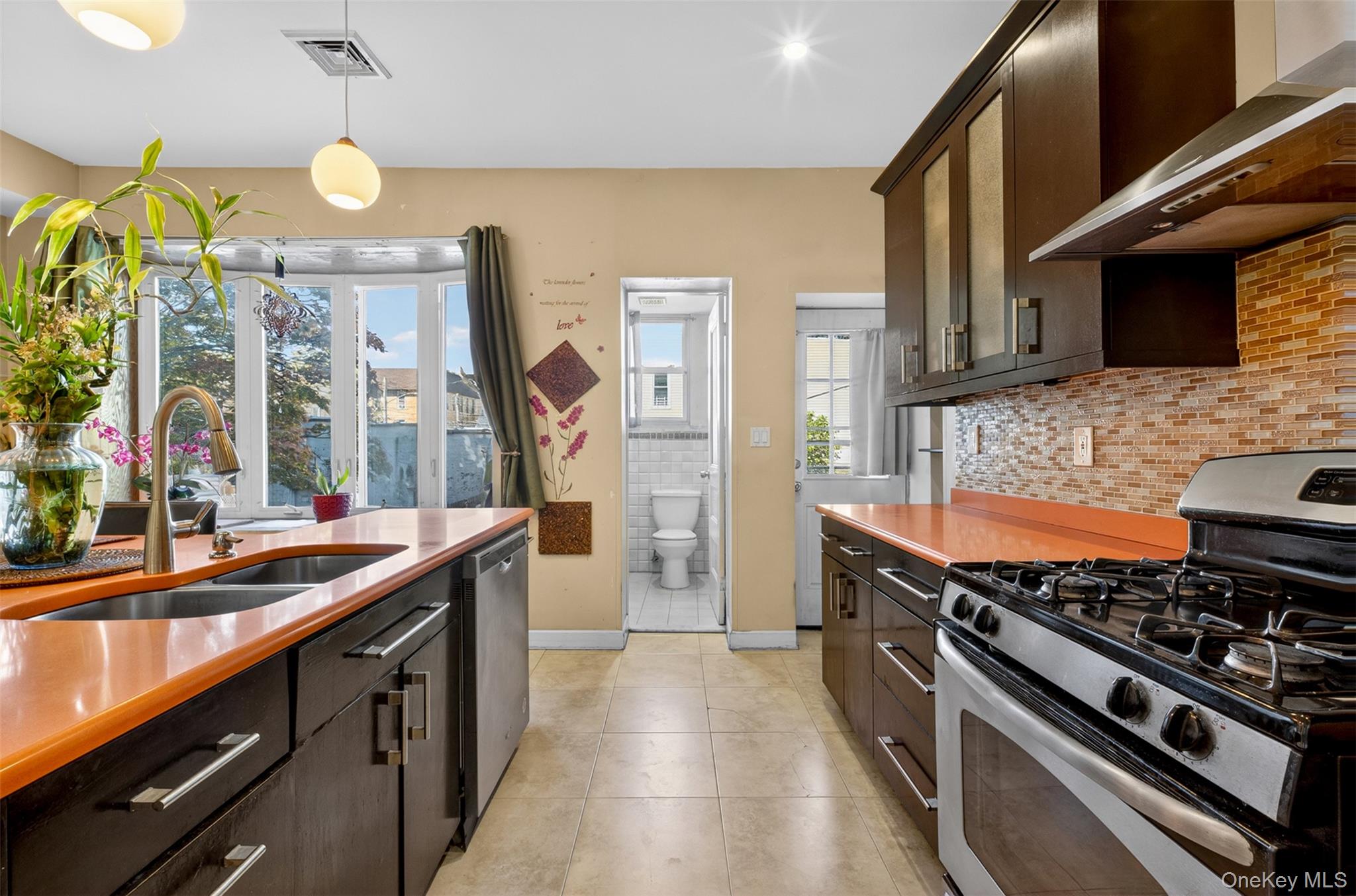 88-42 87th Street Queens, NY 11421 - Photo 10 of 33 a kitchen with stainless steel appliances a stove and a sink