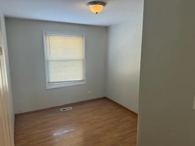 an empty room with a window and a fan