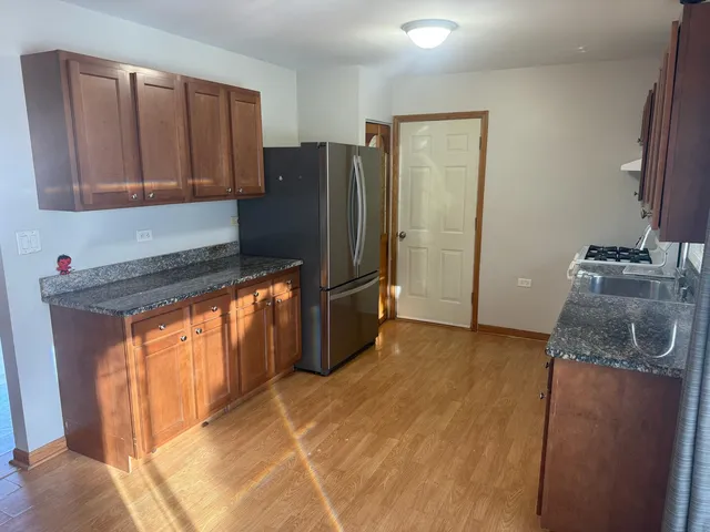 a kitchen with stainless steel appliances granite countertop a refrigerator and a sink