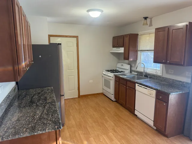 a kitchen with stainless steel appliances granite countertop a stove a sink and a refrigerator