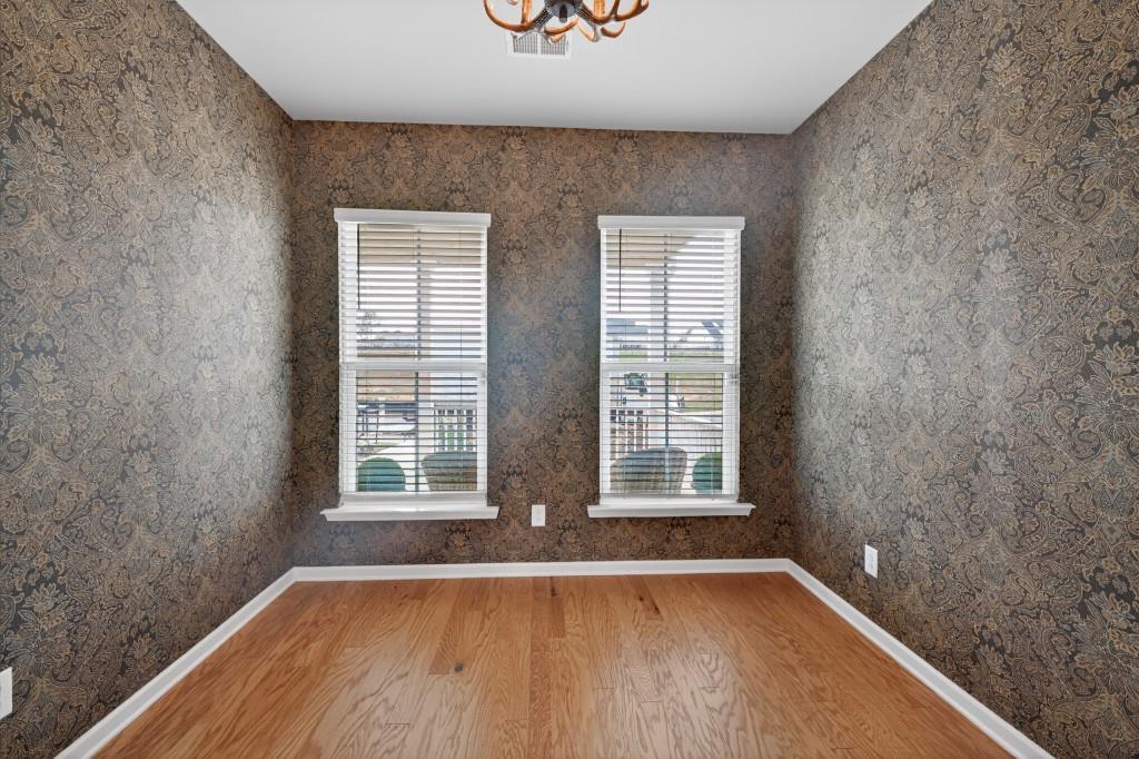 7277 Maple Brook Lane Flowery Branch, GA 30542 - Photo 13 of 57 a view of an empty room with wooden floor and a window