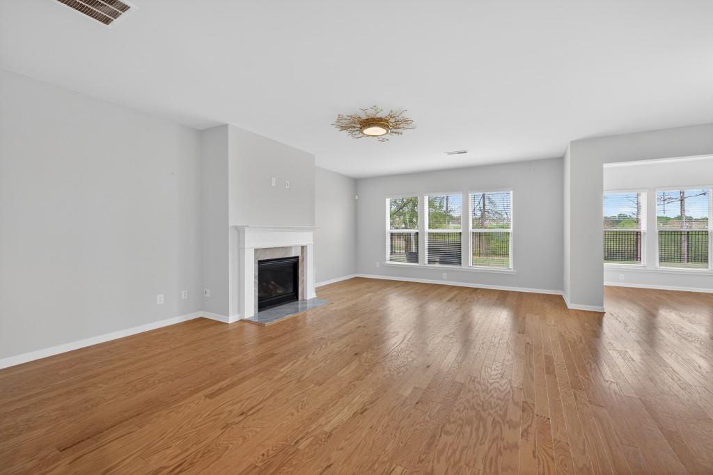 7277 Maple Brook Lane Flowery Branch, GA 30542 - Photo 15 of 57 a view of empty room with wooden floor and fireplace