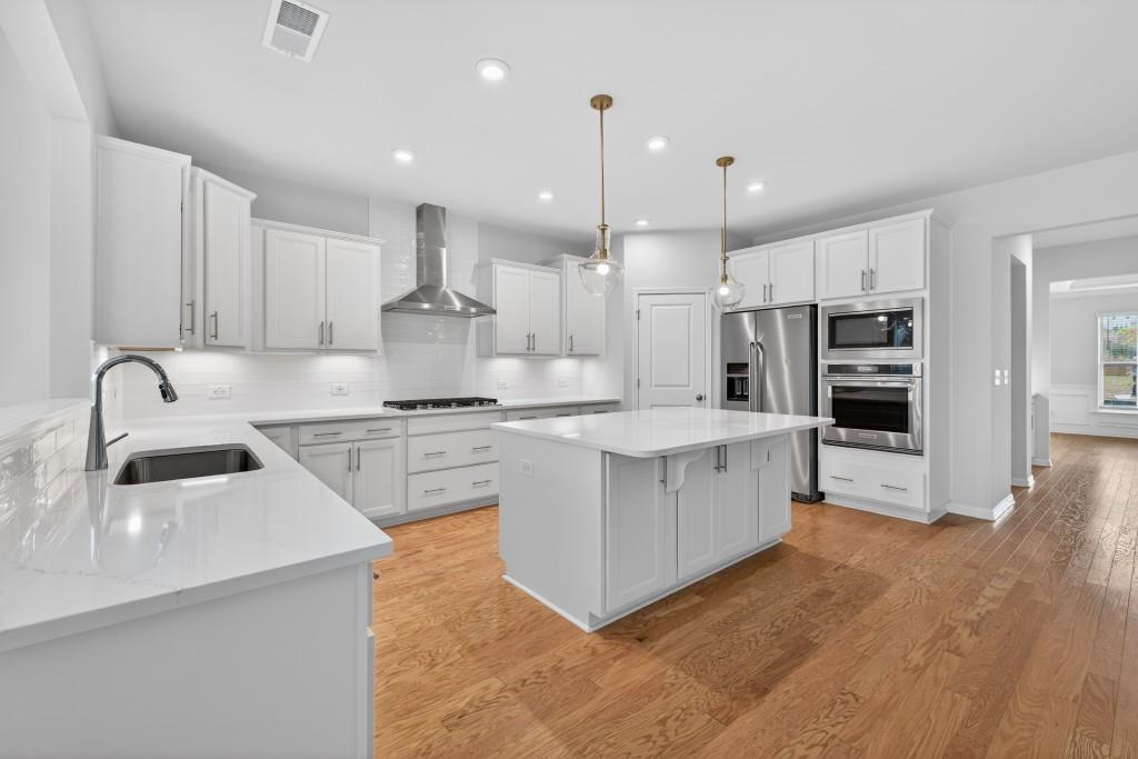 7277 Maple Brook Lane Flowery Branch, GA 30542 - Photo 22 of 57 a kitchen with kitchen island granite countertop a sink cabinets and stainless steel appliances