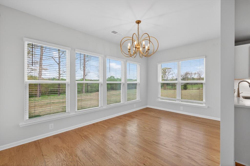 7277 Maple Brook Lane Flowery Branch, GA 30542 - Photo 24 of 57 a view of an empty room with wooden floor and a window