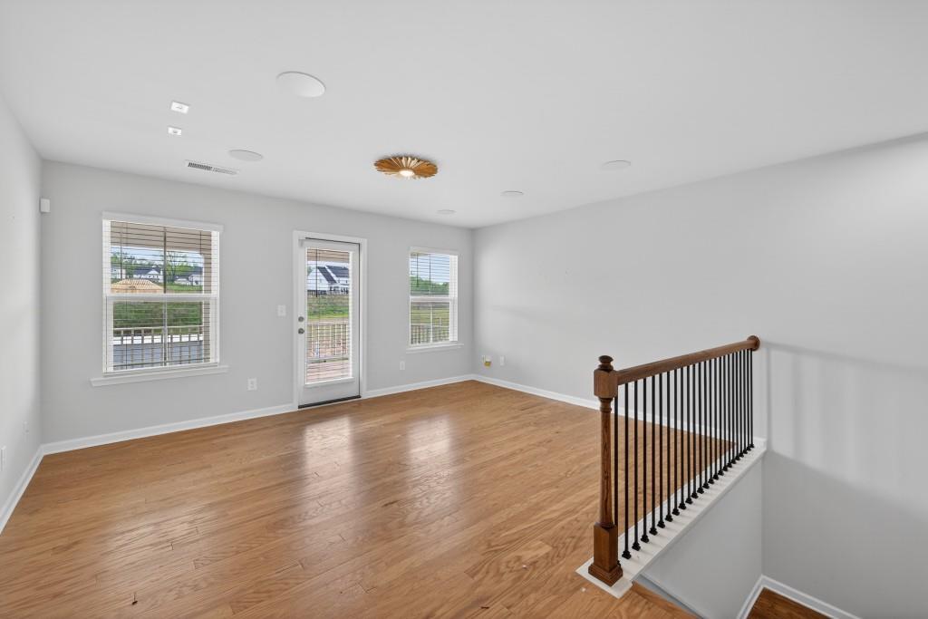 7277 Maple Brook Lane Flowery Branch, GA 30542 - Photo 33 of 57 an empty room with wooden floor and windows