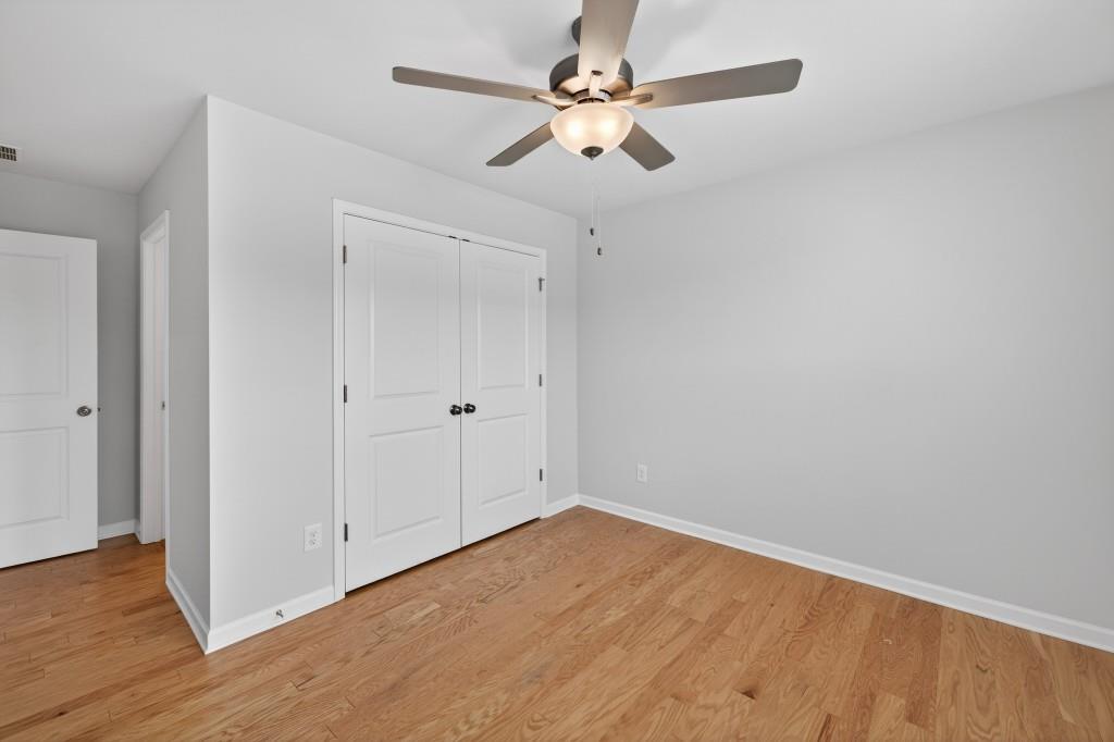 7277 Maple Brook Lane Flowery Branch, GA 30542 - Photo 36 of 57 an empty room with wooden floor fan and windows