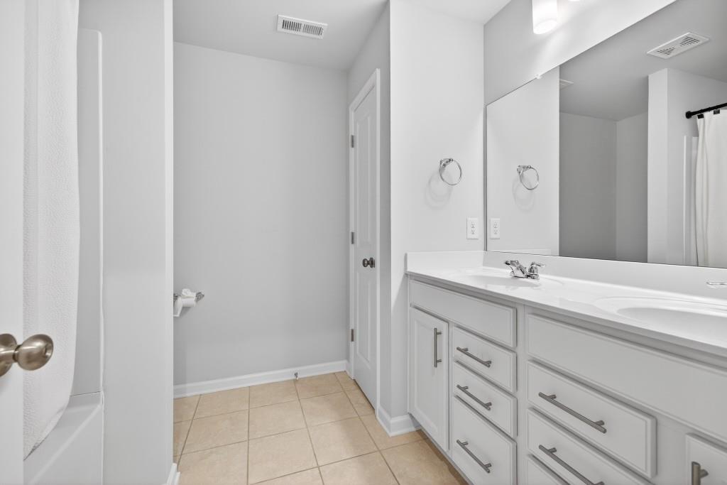 7277 Maple Brook Lane Flowery Branch, GA 30542 - Photo 42 of 57 a bathroom with a double vanity sink a mirror and a shower