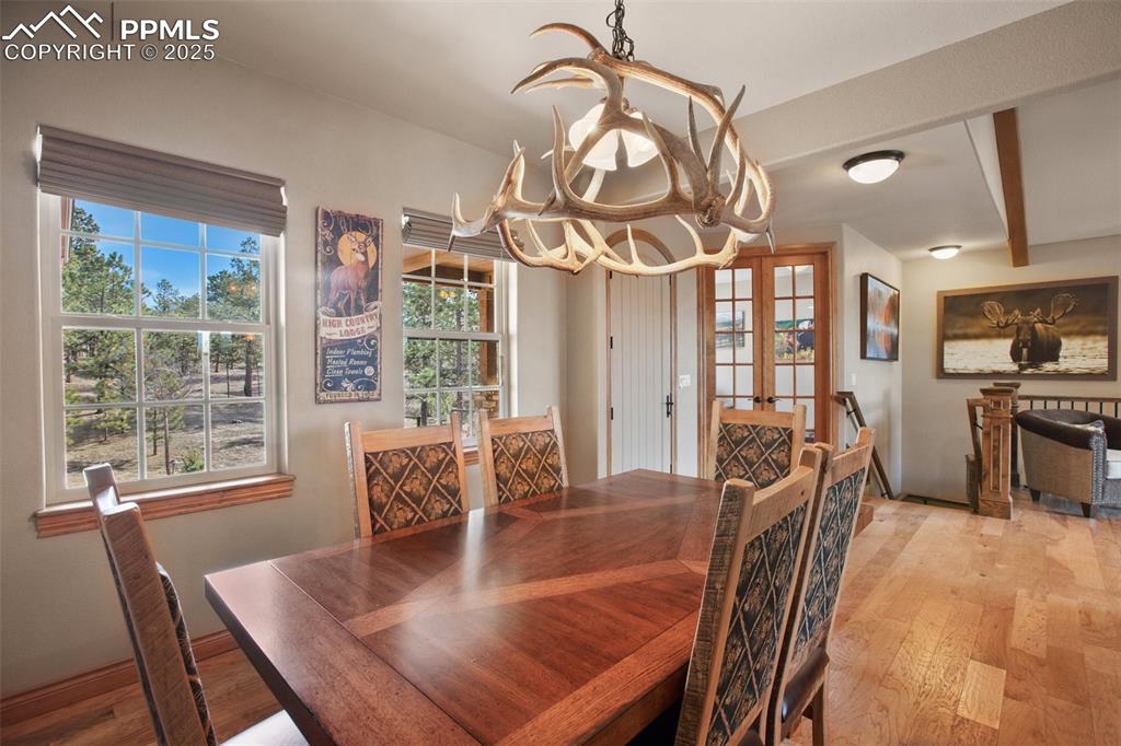 5070 Vessey Road Colorado Springs, CO 80908 - Photo 15 of 49 Dining area with a notable chandelier, french doors, and light wood-type flooring