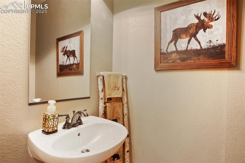 5070 Vessey Road Colorado Springs, CO 80908 - Photo 17 of 49 Half-Bathroom with a textured wall and a sink
