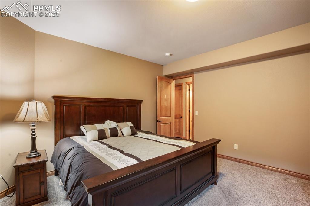 5070 Vessey Road Colorado Springs, CO 80908 - Photo 23 of 43 Bedroom featuring light colored carpet and baseboards