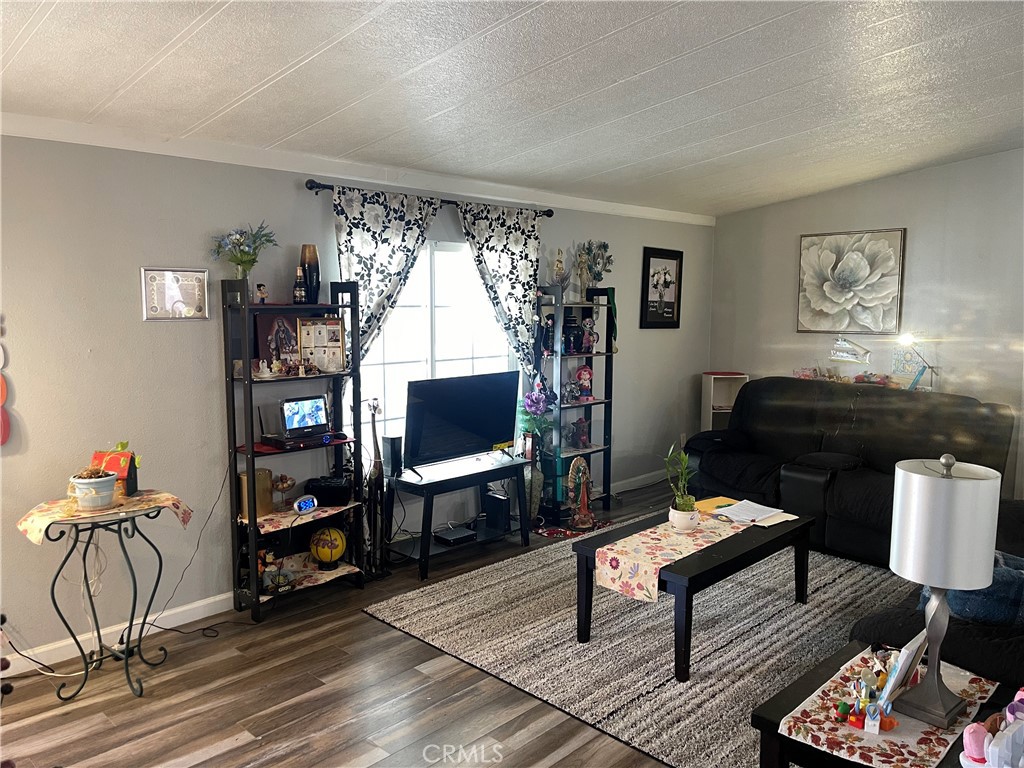 350 East San Jacinto Avenue, Unit 121 Perris, CA 92571 - Photo 16 of 24 a living room with furniture a bookshelf and a window