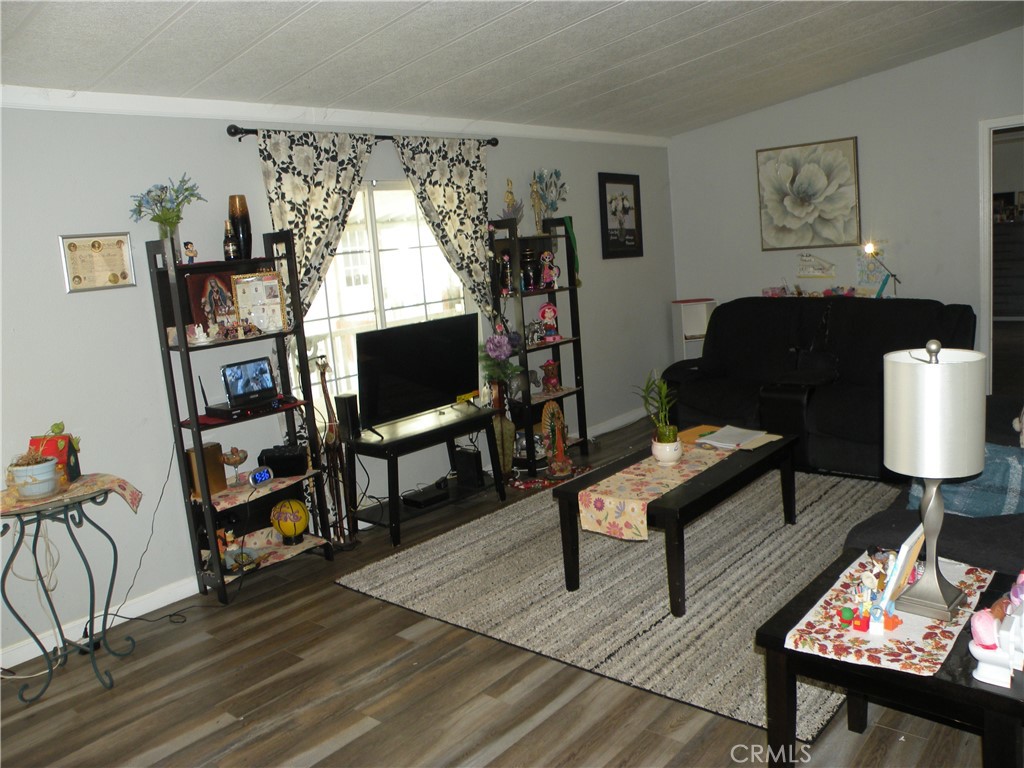 350 East San Jacinto Avenue, Unit 121 Perris, CA 92571 - Photo 5 of 24 a living room with furniture a bookshelf and a window