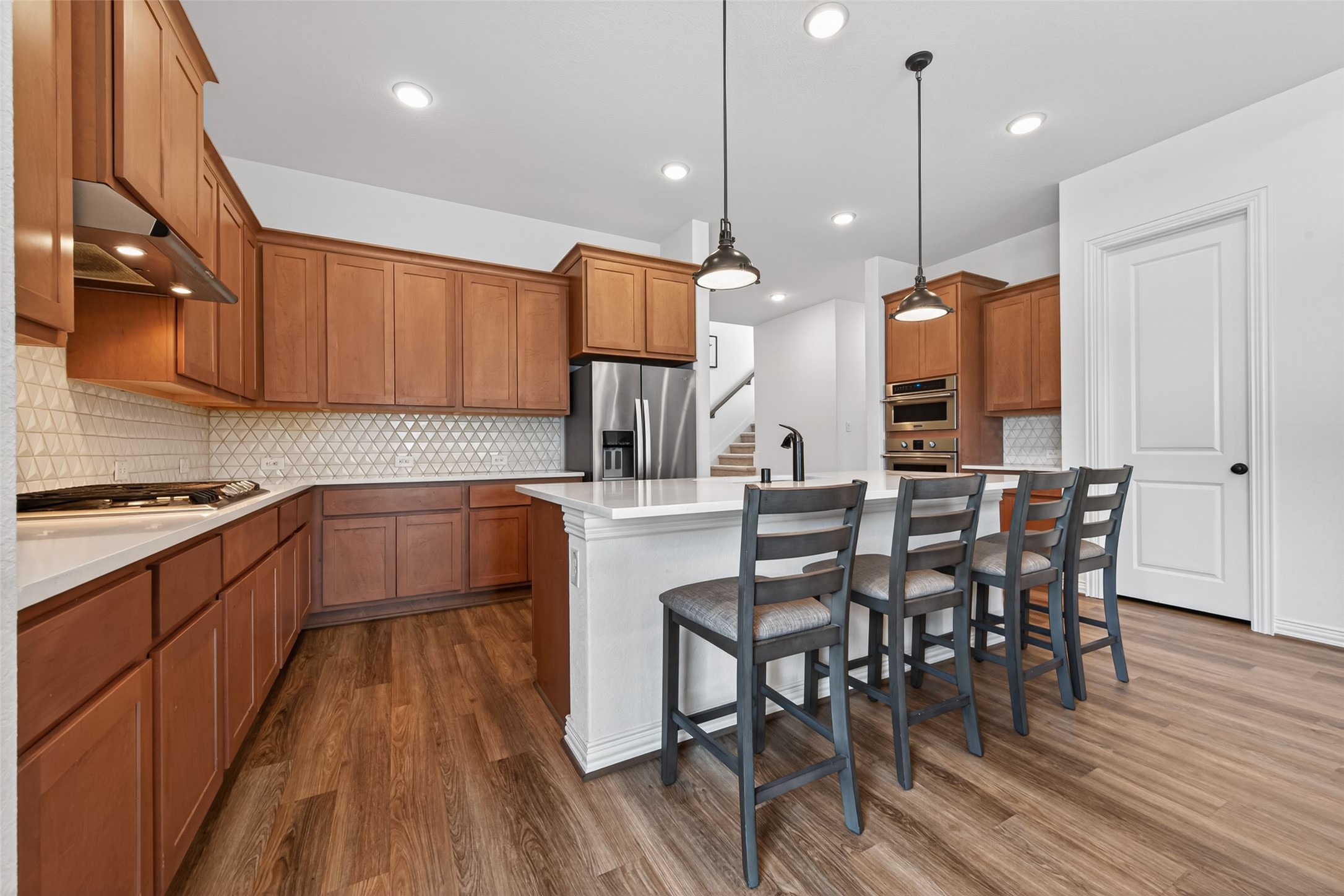 20802 Mirror Point Drive Cypress, TX 77433 - Photo 7 of 37 The kitchen features beautiful cabinetry, a spacious island perfect for bar seating. The space is enhanced by stylish details like a lovely backsplash and smart recessed lighting, further improved with generous storage.