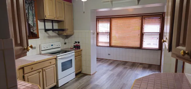a kitchen with a wooden floor and a stove top oven