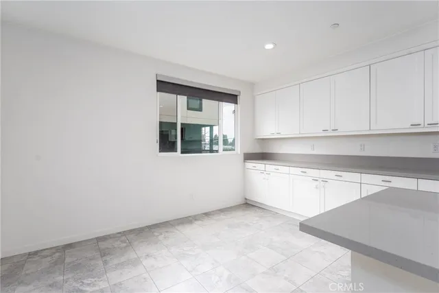 a kitchen with granite countertop white cabinets and window