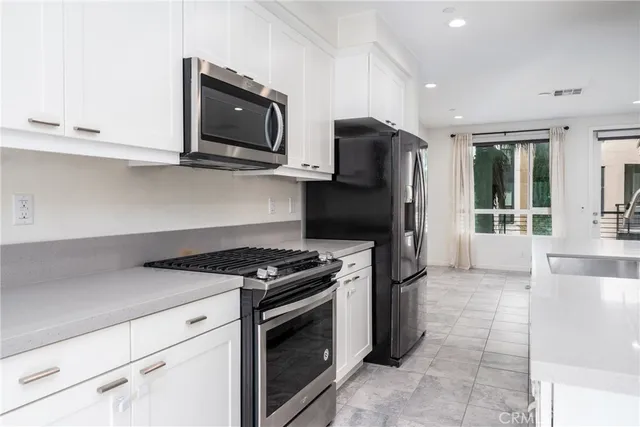 a kitchen with stainless steel appliances granite countertop a stove a microwave and a refrigerator