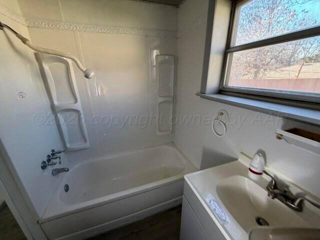 822 East Santa Fe Avenue Canadian, TX 79014 - Photo 13 of 19 a bathroom with a sink a toilet and a bathtub
