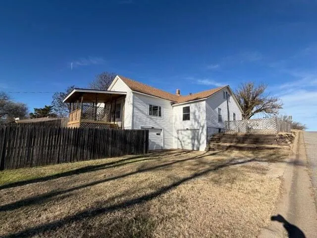 a view of a house with a small yard and wooden fence