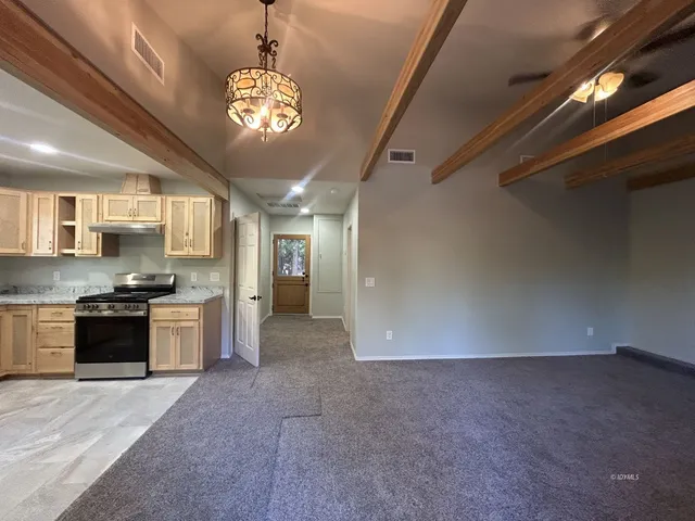 a large kitchen with a stove and a chandelier