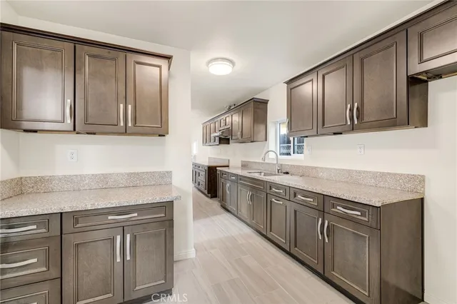 a kitchen with granite countertop cabinets stainless steel appliances a sink and wooden floor