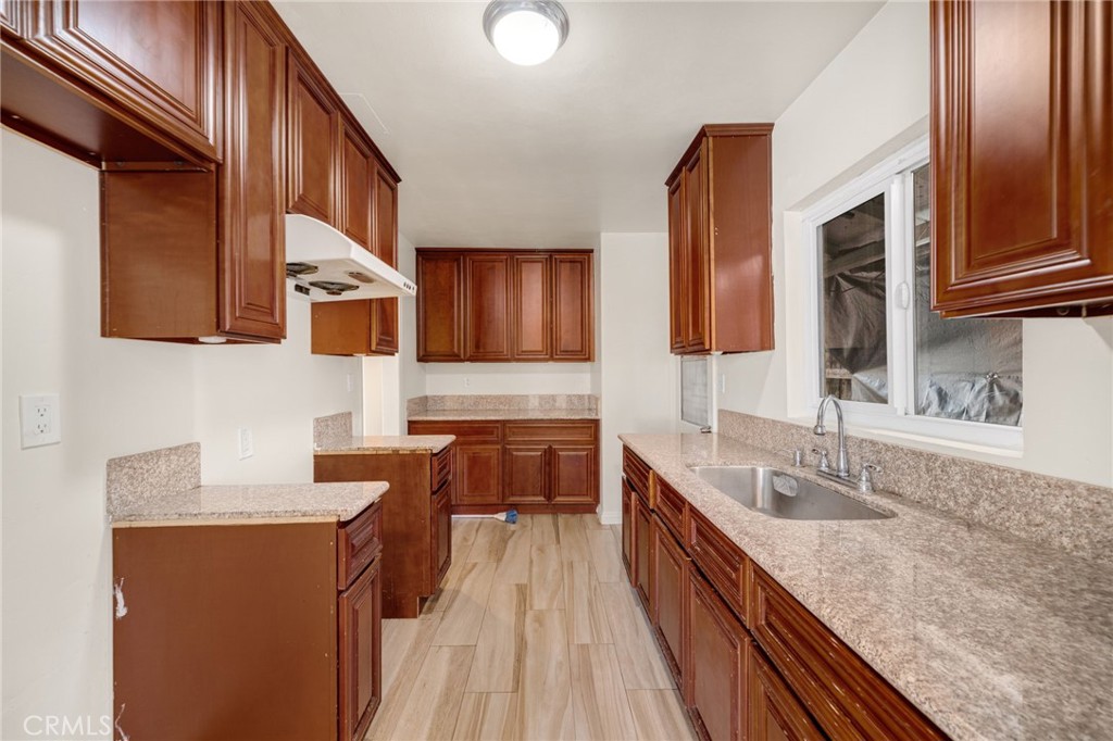 13223 3rd Street Chino, CA 91710 - Photo 9 of 15 a kitchen with stainless steel appliances granite countertop wooden cabinets a sink and dishwasher a stove top oven with wooden floor