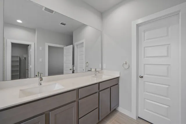 a bathroom with a double vanity sink and a mirror