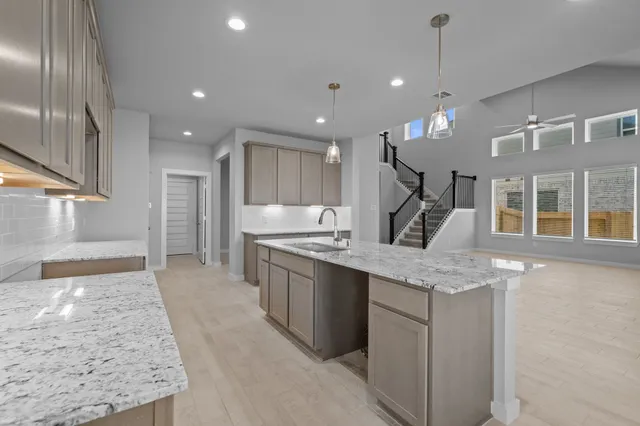 a large kitchen with stainless steel appliances kitchen island a large counter top and a wooden floors