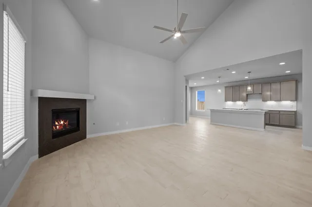 a view of an empty room with a fireplace and a window