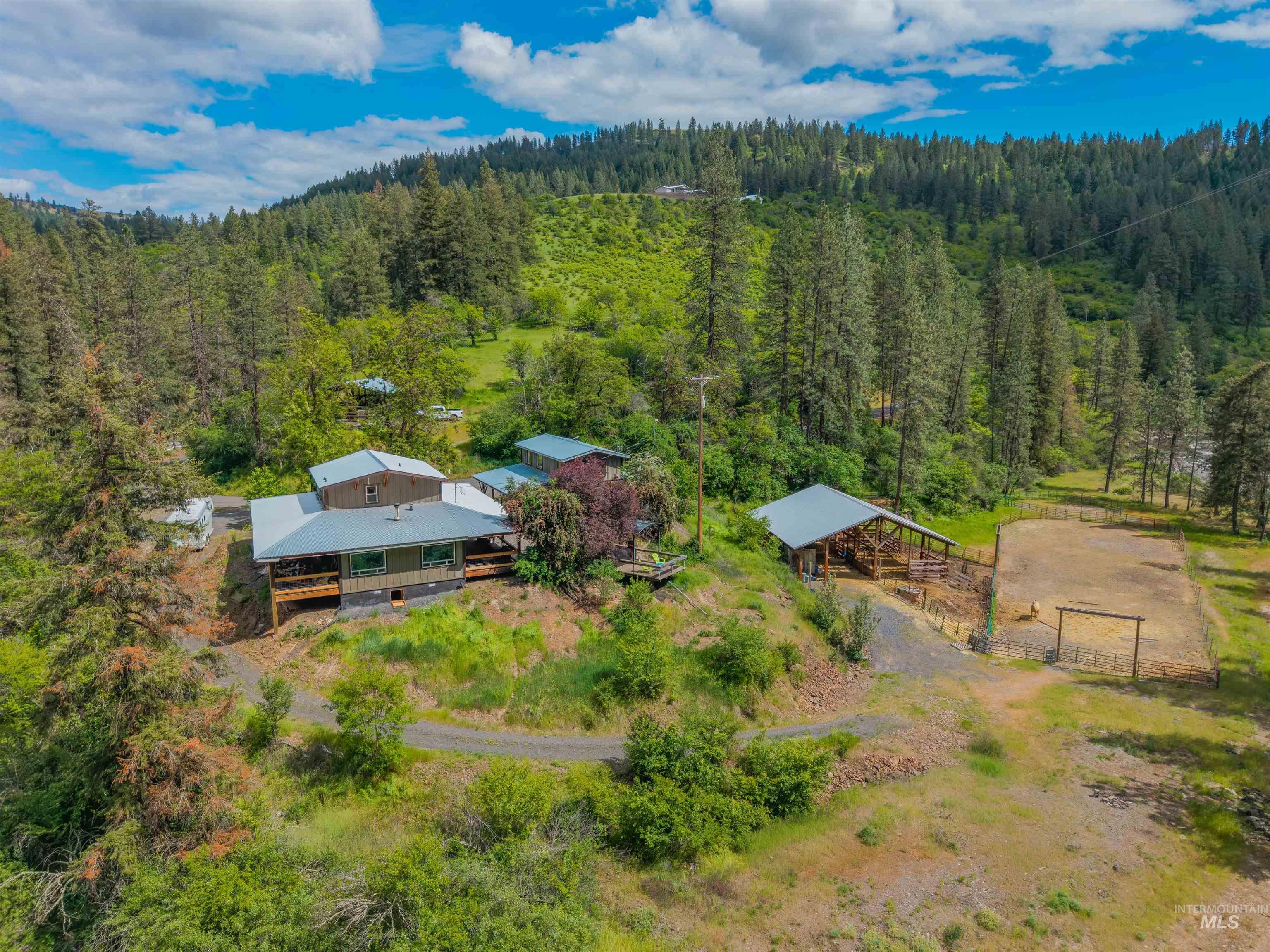 Expansive property featuring a multi-level dwelling with a metal roof and an outdoor deck