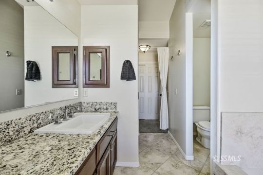 1260 Arroyo Street Ridgecrest, CA 93555 - Photo 22 of 44 a bathroom with a granite countertop sink and a mirror