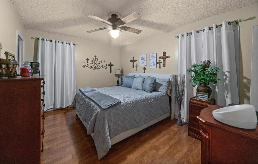 6753 Murphy Street Murchison, TX 75778 - Photo 11 of 24 a bedroom with a large bed and a chandelier