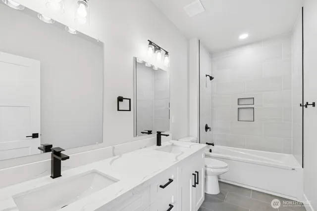 a bathroom with a tub sink toilet and a mirror