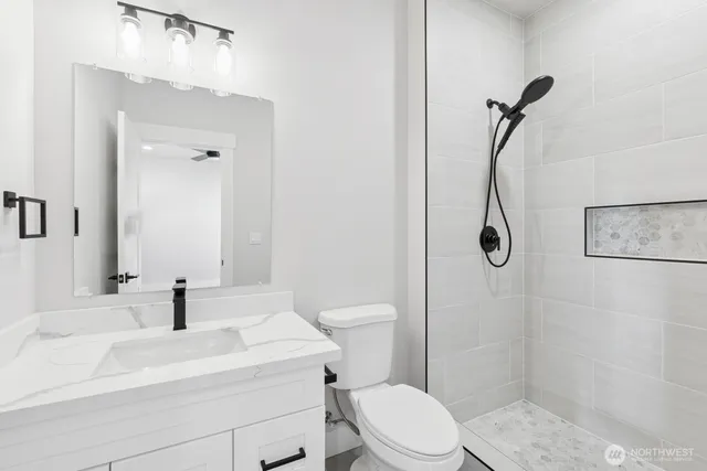 a bathroom with a sink a toilet and shower