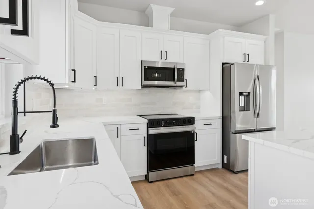 a kitchen with white cabinets and stainless steel appliances