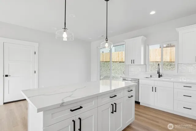 a kitchen with stainless steel appliances a sink a center island and cabinets