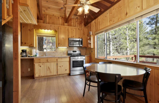 39187 Arapahoe Road Fawnskin, CA 92333 - Photo 16 of 18 a kitchen with a table chairs stove and cabinets