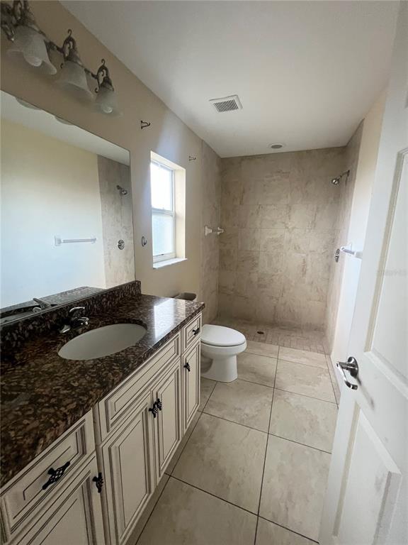 3281 Easy Street Port Charlotte, FL 33952 - Photo 6 of 8 a bathroom with a granite countertop sink a toilet and a mirror