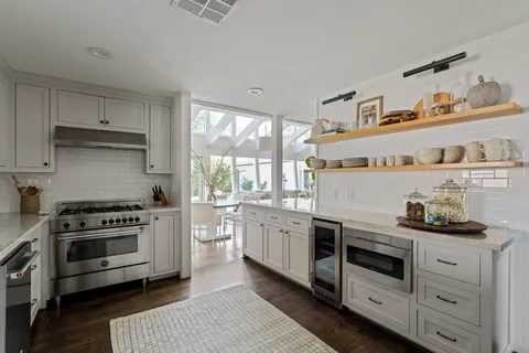 a kitchen with kitchen island granite countertop white cabinets and white appliances