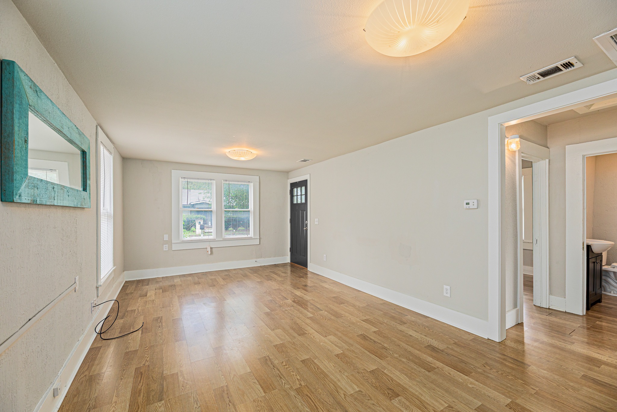 322 Blanco Avenue Luling, TX 78648 - Photo 4 of 20 Sun-filled living area features natural wood floors and ample window light.