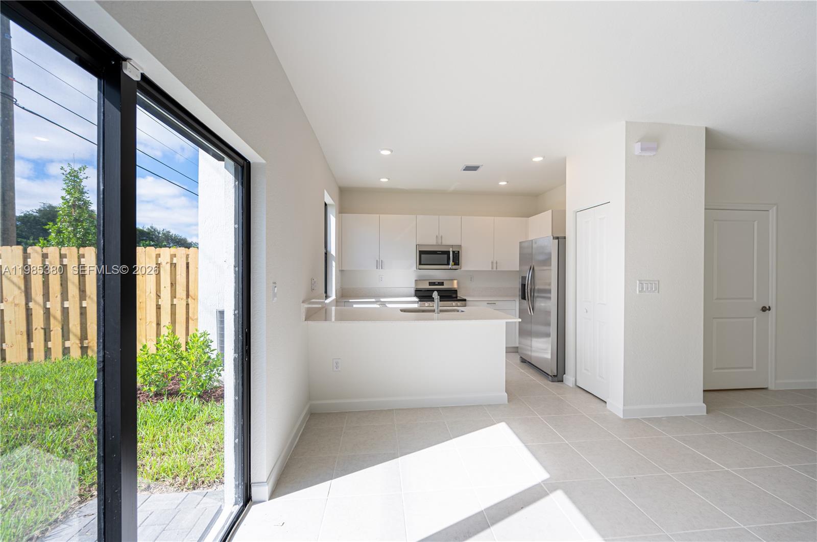 13380 Southwest 287th Terrace Homestead, FL 33033 - Photo 7 of 21 a view of kitchen with stainless steel appliances refrigerator oven and white cabinets with wooden floor