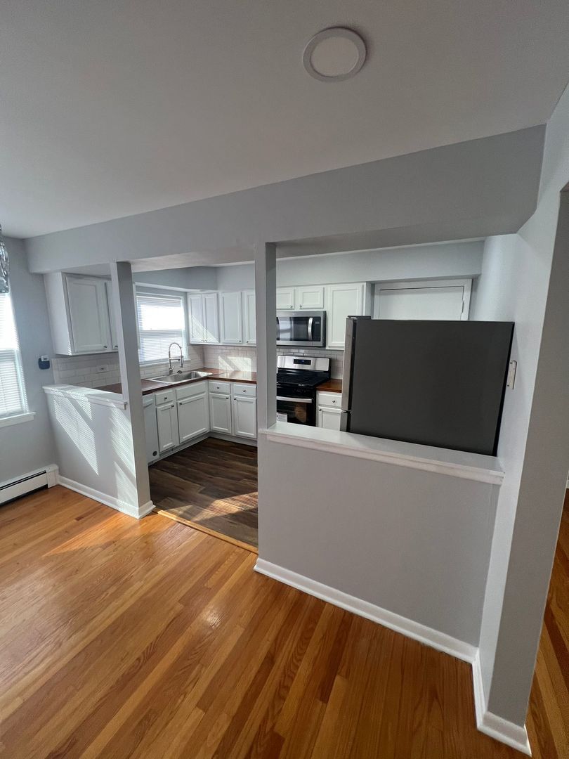 2348 West 111th Street, Unit 2 Chicago, IL 60643 - Photo 14 of 23 a living room with stainless steel appliances kitchen island granite countertop a refrigerator a stove a microwave oven with white cabinets and wooden floor