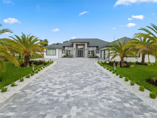 a front view of a house with a yard and potted plants