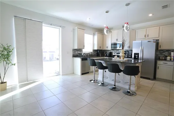 a kitchen with stainless steel appliances kitchen island granite countertop a refrigerator and a stove top oven