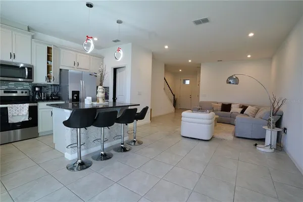 a kitchen with granite countertop a sink and white cabinets