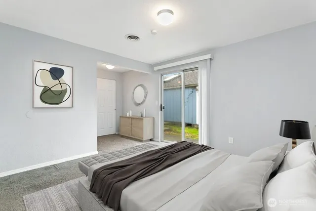 a bedroom with a bed and painting on the wall