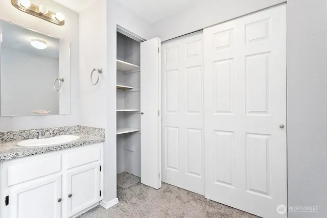 a bathroom with a granite countertop sink and a mirror