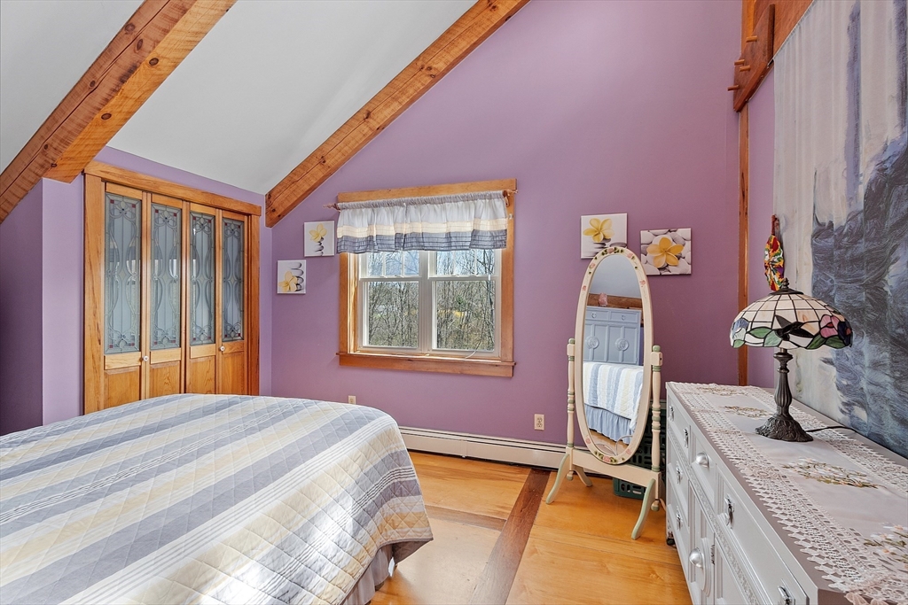31 Dutton Road Pelham, NH 03076 - Photo 16 of 36 a bedroom with a bed and a chandelier