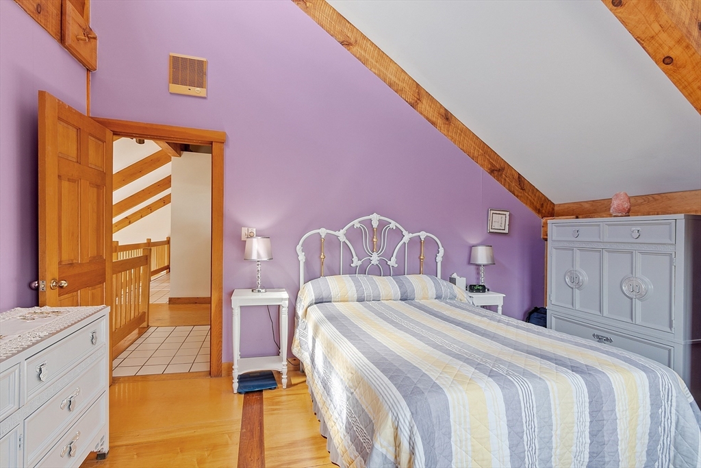 31 Dutton Road Pelham, NH 03076 - Photo 17 of 36 a spacious bedroom with a bed and a chandelier